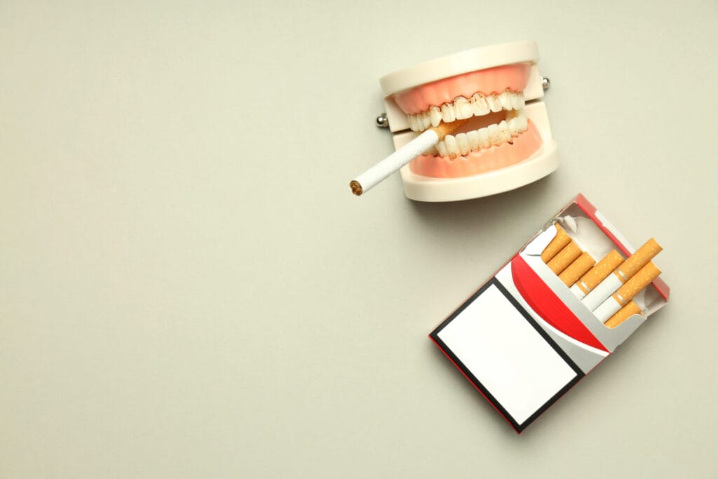 Tandmodel med cigaret og åben cigaretpakke